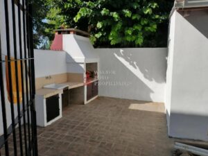 Patio con parrilla mesada lavadero y guarda-cosas.